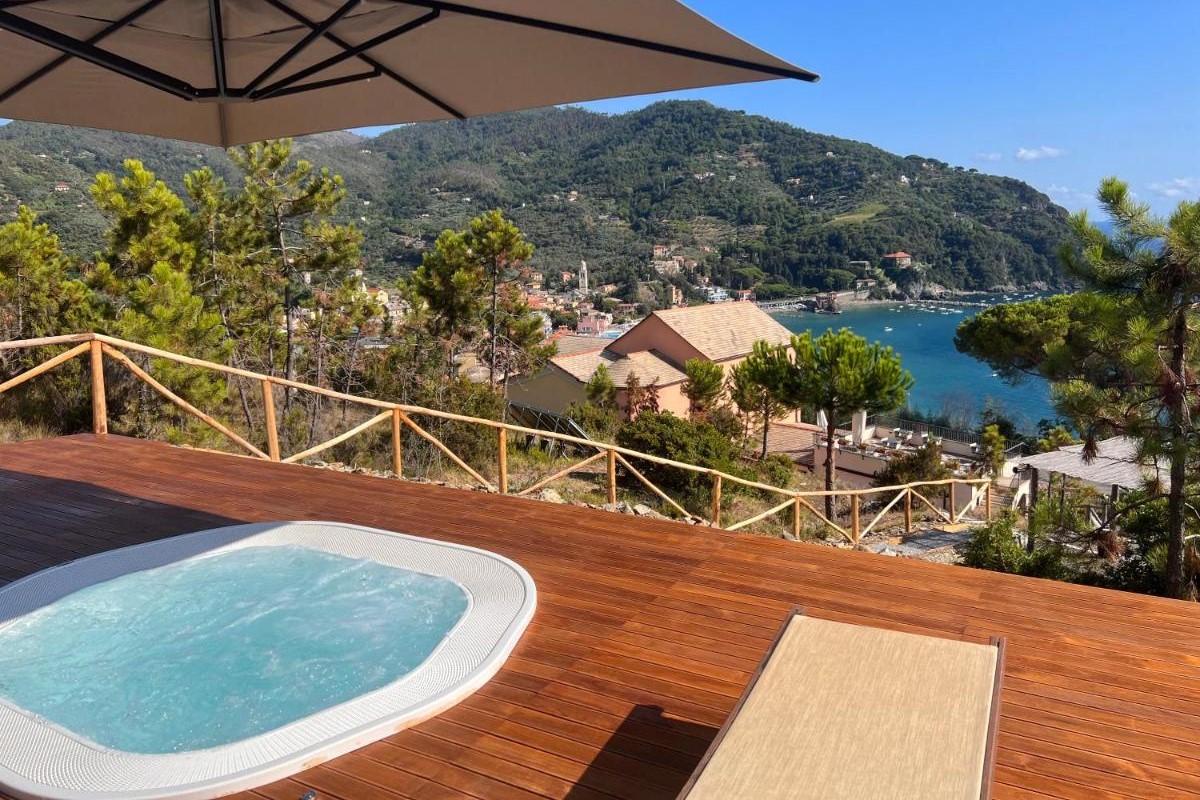 View of the town of Levanto from the terrace of a guesthouse with a jacuzzi in the foreground.